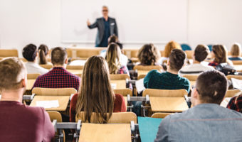Rear view of large group of students on a class at lecture hall.